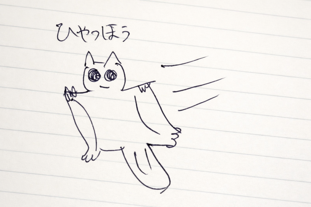 手書きのノートの上に、翼のような腕を広げて飛んでいる猫のようなキャラクターの落書き。「ひゃっほう」と書かれており、勢いよく飛んでいる様子が線で表現されている。